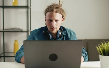 Stock Footage Urban Man Browses Web On Laptop With Headphones