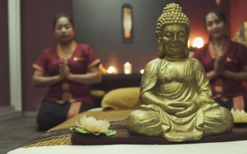 Stock Footage Two Monks Kneeling Behind Golden Buddha