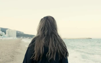 Stock Footage Woman Walking Along A Coastal Town Beach Free
