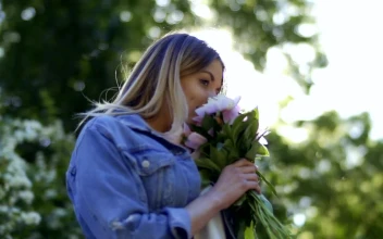 Stock Footage Woman In Denim Jacket Smelling Flowers On Spring Day Free