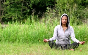 Stock Footage Woman In Hoodie Meditating On The Grass Free