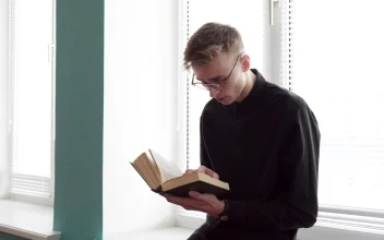 Stock Footage Young Man Reading Against The Window Free
