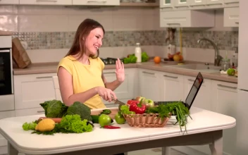 Stock Footage Woman Prepares Dinner While Video Chatting On Laptop Free