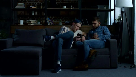 Stock Video A Couple Of Friends Sitting Laughing With Their Cell Phones Live Wallpaper for PC - Free Live Wallpaper