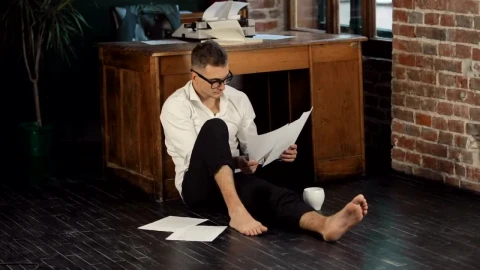 Stock Video Barefoot Writer Sits On Floor Reading Manuscript Live Wallpaper For PC - Free Live Wallpaper