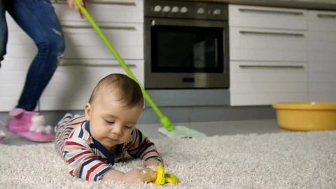 Stock Video Baby Lying On A Rug While Her Mother Cleans Behind Live Wallpaper For PC - Free Live Wallpaper