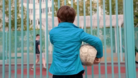 Stock Video Boy Holding Deflated Ball Watching Other Kids Playing Football Live Wallpaper For PC - Free Live Wallpaper
