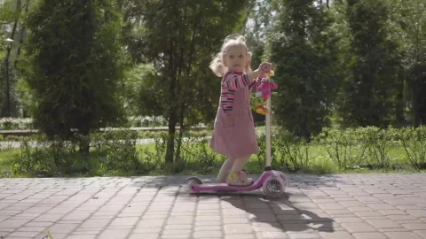 Stock Video Cute Little Girl Rides Scooter Down Brick Sidewalk Live Wallpaper For PC - Free Live Wallpaper