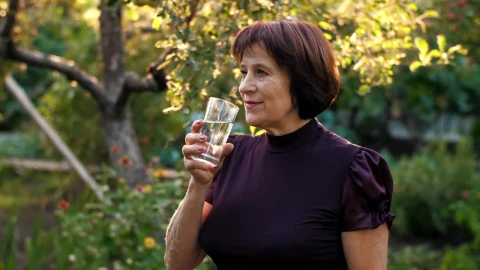 Stock Video Elderly Woman Drinking Water In Her Home Garden Live Wallpaper For PC - Free Live Wallpaper