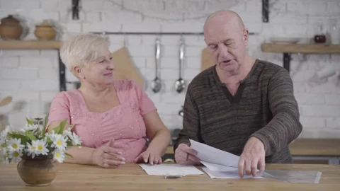 Stock Video Elderly Couple Discuss Bills In Kitchen Live Wallpaper For PC - Free Live Wallpaper