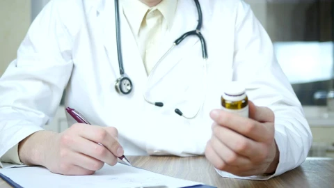 Stock Video Doctor Writing A Prescription Holding A Medicine Container Live Wallpaper For PC - Free Live Wallpaper