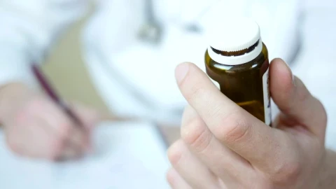 Stock Video Doctor Writing A Prescription Holding A Bottle Of Pills Live Wallpaper For PC - Free Live Wallpaper
