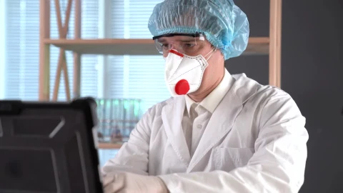 Stock Video Doctor Using A Facemask Typing On A Computer Live Wallpaper For PC - Free Live Wallpaper