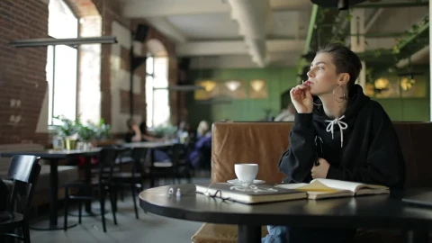 Stock Video Hip Woman Thinking In Cafe Writes Down Idea Animated Wallpaper - Free Live Wallpaper