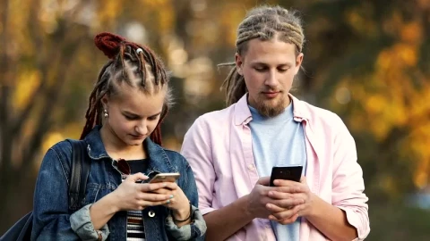 Stock Video Hip Urban Couple Surf Internet On Mobile Phones Outside In Animated Wallpaper - Free Live Wallpaper