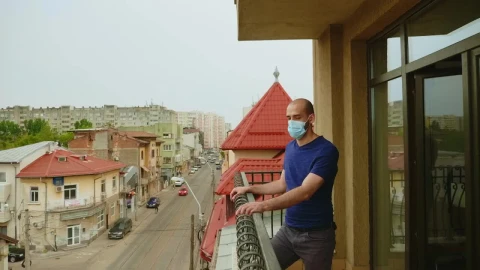 Stock Video Man In Face Mask Thinks About Quarantine On Balcony Animated Wallpaper - Free Live Wallpaper