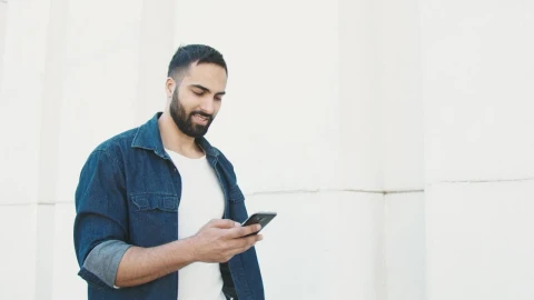 Stock Video Man In Denim Jacket Holding Phone And Walking Along White Animated Wallpaper - Free Live Wallpaper