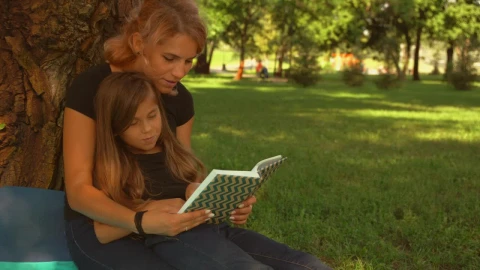 Stock Video Mother And Daughter Read A Book Together In A Par Animated Wallpaper - Free Live Wallpaper