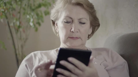 Stock Video Mature Woman Using An Electronic Reading Devic Animated Wallpaper - Free Live Wallpaper