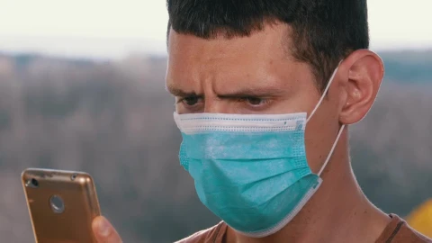Stock Video Man With A Face Mask Looking At Smart Phon Animated Wallpaper - Free Live Wallpaper
