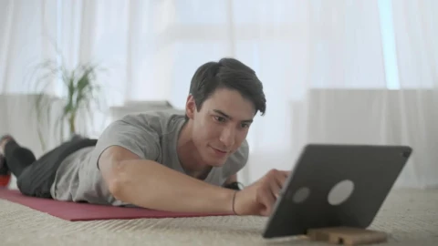 Stock Video Man Watching Exercises On A Tablet To Practice The Animated Wallpaper - Free Live Wallpaper