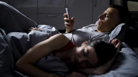 Stock Video Man Using His Phone While His Wife Sleep Animated Wallpaper - Free Live Wallpaper