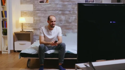 Stock Video Man Sits On Bed Laughing At Comedy On T Animated Wallpaper - Free Live Wallpaper