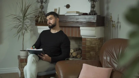 Stock Video Man Sits In Living Room Thinking And Writin Animated Wallpaper - Free Live Wallpaper