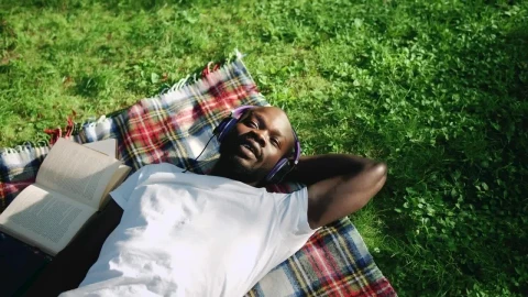 Stock Video Man Sings Along To Music Lying In Park With Headphone Animated Wallpaper - Free Live Wallpaper