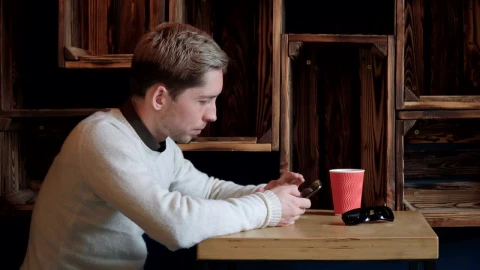 Stock Video Man Scrolling Through His Phone In A Caf Animated Wallpaper - Free Live Wallpaper