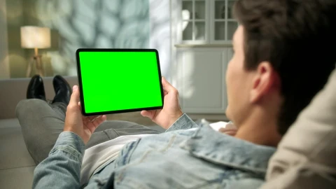 Stock Video Man Relaxing With Green Screen Tablet In Neutral Roo Animated Wallpaper - Free Live Wallpaper