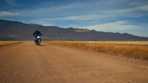 Stock Video Motorcyclist Crossing A Dirt Road In A Desert Live Wallpaper - Free Live Wallpaper