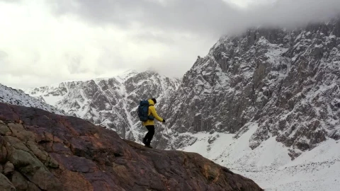 Stock Video Mountaineer Walking On A Cliff In A Winter Mountain Range Live Wallpaper - Free Live Wallpaper