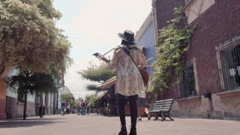 Stock Video Mujer Caminando Por Una Calle Colonial Mientras Toca Su Guitarra Live Wallpaper - Free Live Wallpaper
