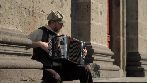 Stock Video Musician Playing Accordion In Front Of A Concrete Building Live Wallpaper - Free Live Wallpaper