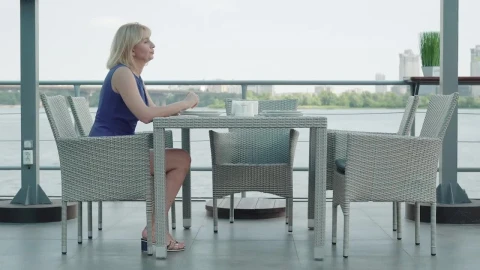 Stock Video Nervous Woman Waits Alone At Outdoor Restaurant Live Wallpaper - Free Live Wallpaper