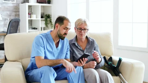 Stock Video Nurse Helps Woman Use App On Mobile Phone Live Wallpaper - Free Live Wallpaper