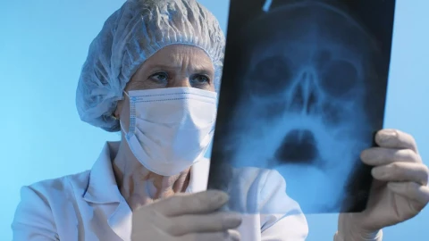 Stock Video Old Female Doctor Looking At An X Ray Wearing Face Mask Live Wallpaper - Free Live Wallpaper