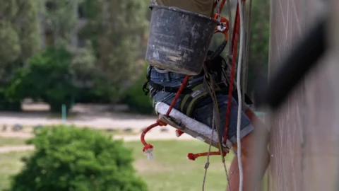 Stock Video Painter Repairing The External Wall Of A Building Live Wallpaper - Free Live Wallpaper