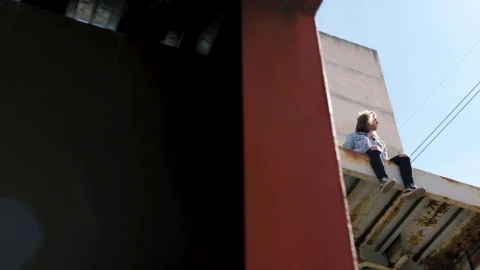Video Stock Person Sits On Awning Of Abandoned Building Live Wallpaper Free - Free Live Wallpaper