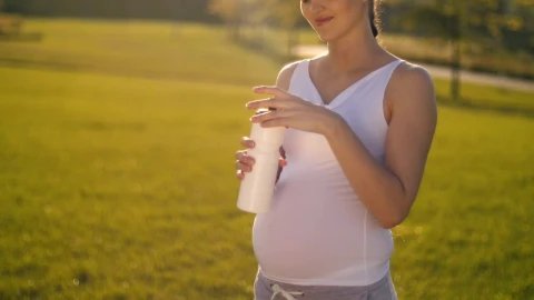 Video Stock Pregnant Woman Drinks Water On Her Walk In The Park Live Wallpaper Free - Free Live Wallpaper