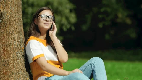 Video Stock Pretty Girl In Glasses Says Hello On Mobile In Park Live Wallpaper Free - Free Live Wallpaper