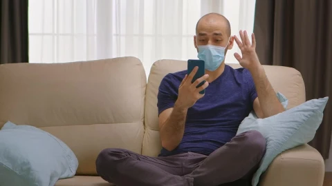 Video Stock Quarantined Man Chats On Smartphone On Couch Live Wallpaper Free - Free Live Wallpaper