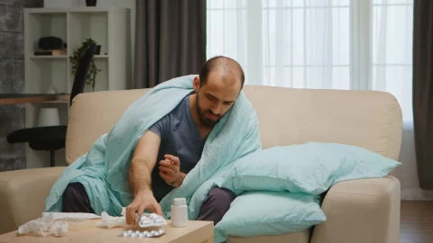 Video Stock Quarantined Sick Man Sits On Sofa Holding Medication Live Wallpaper Free - Free Live Wallpaper