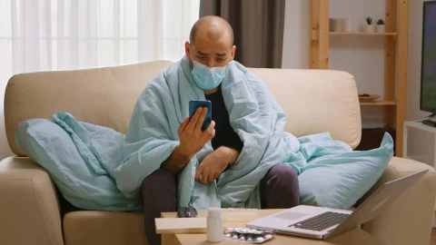 Video Stock Quarantined Man With Smartphone Video Chats On Sofa Live Wallpaper Free - Free Live Wallpaper