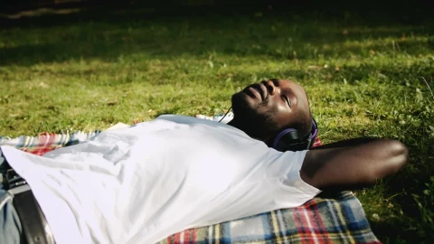 Free Stock Video Relaxed Man Enjoys Music While Lying On Grass Live Wallpaper - Free Live Wallpaper