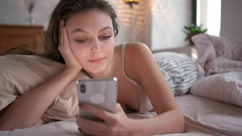Free Stock Video Relaxed Woman On Bed Looking At Her Smartphone Live Wallpaper - Free Live Wallpaper