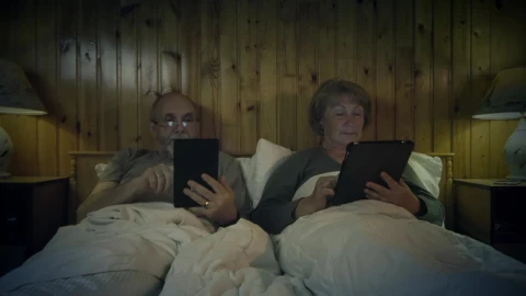 Free Stock Video Senior Couple Reading On The Bed With Devices Live Wallpaper - Free Live Wallpaper