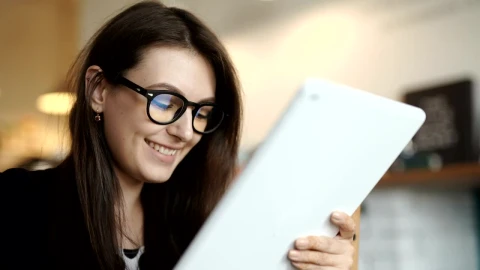 Free Video Stock Smiling Young Woman Surfs Internet On Tablet Live Wallpaper - Free Live Wallpaper