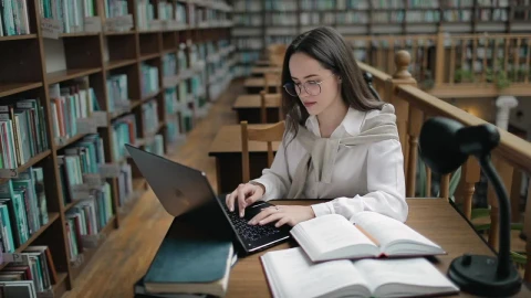 Free Video Stock Student Doing Research In University Library With Books And Laptop Live Wallpaper - Free Live Wallpaper